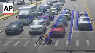 Man dressed as Spider-Man helps a person in a wheelchair cross the road