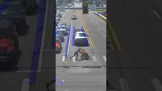 Man dressed as Spider-Man helps person in wheelchair cross street