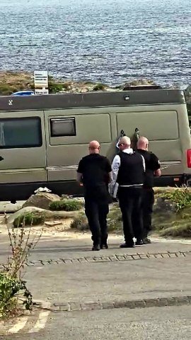Cornwall Council enforcement officers taping direction to leave notices on a vehicle at Towan headland car park